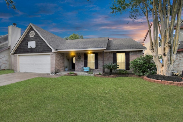 view of front of house featuring brick siding, a yard, a shingled roof, concrete driveway, and an attached garage