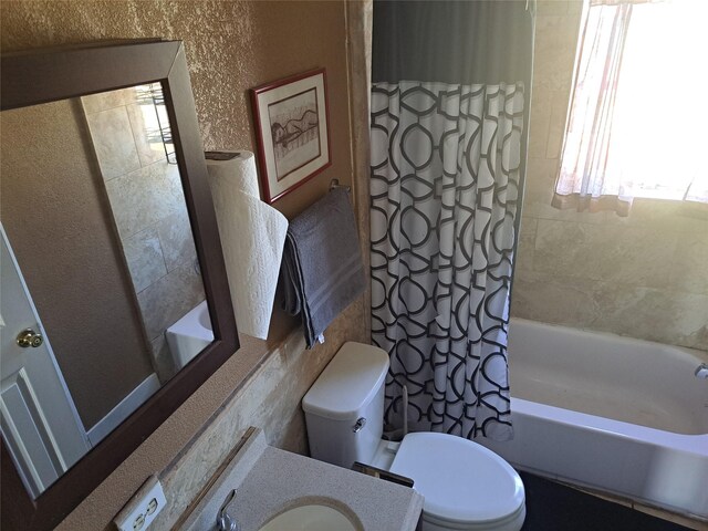 full bathroom featuring shower / bath combo, vanity, and toilet