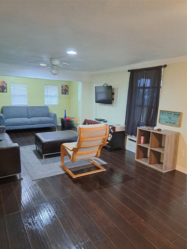 living room featuring ceiling fan, crown molding, dark hardwood / wood-style floors, and a textured ceiling