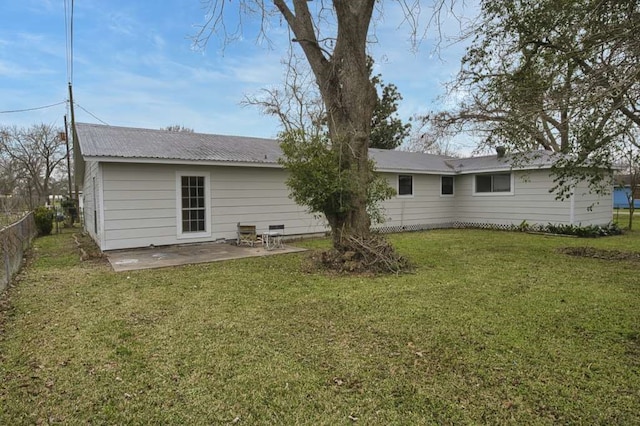 back of house with a lawn and a patio