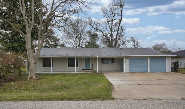 ranch-style home featuring a garage, driveway, metal roof, covered porch, and a front yard