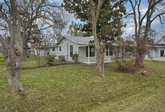 view of front facade featuring a front lawn, central AC unit, and fence