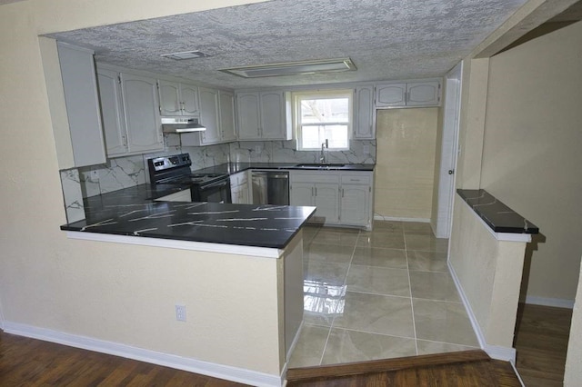 kitchen with dishwasher, a textured ceiling, decorative backsplash, black / electric stove, and kitchen peninsula