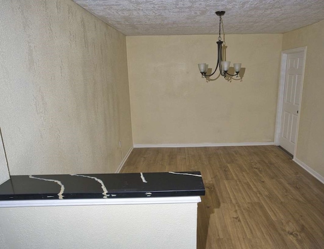 interior space featuring an inviting chandelier, wood-type flooring, and decorative light fixtures