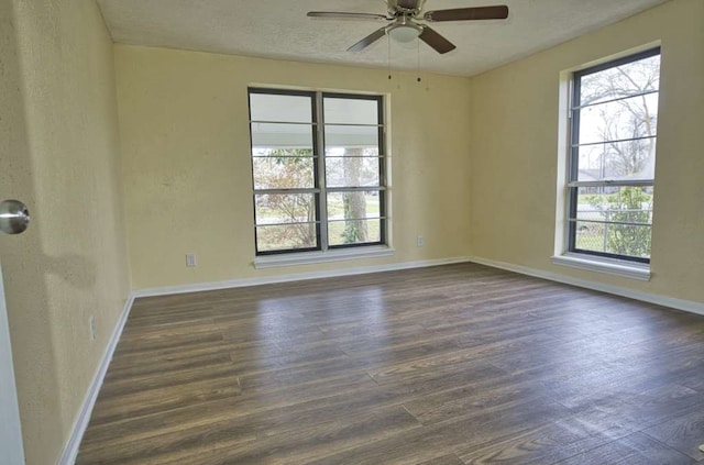 spare room featuring ceiling fan, dark wood-type flooring, and a textured ceiling