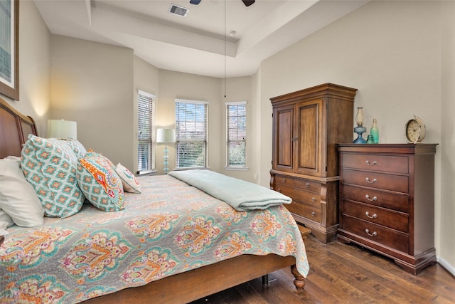 bedroom featuring a tray ceiling, ceiling fan, and dark hardwood / wood-style flooring