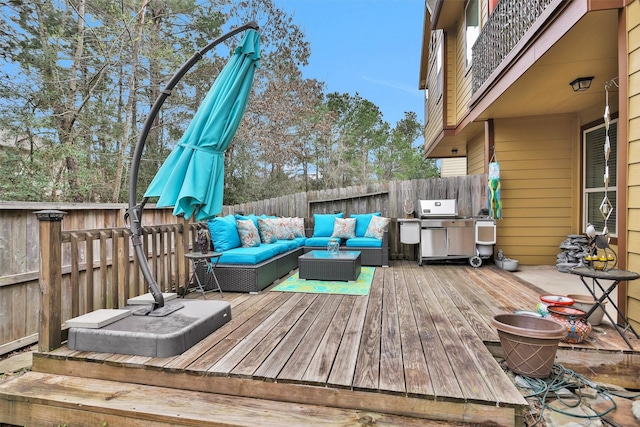 wooden terrace with an outdoor hangout area and grilling area