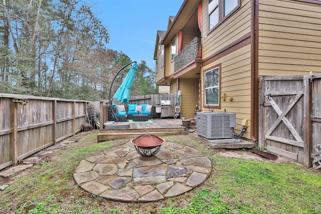 view of yard with a deck, central AC unit, and an outdoor living space with a fire pit