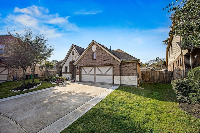 english style home with driveway, brick siding, stone siding, fence, and a front yard