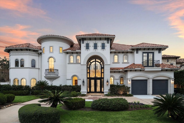 mediterranean / spanish-style home with a garage and french doors