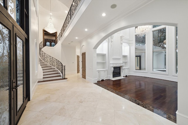 foyer with a fireplace, ornamental molding, and light tile patterned floors