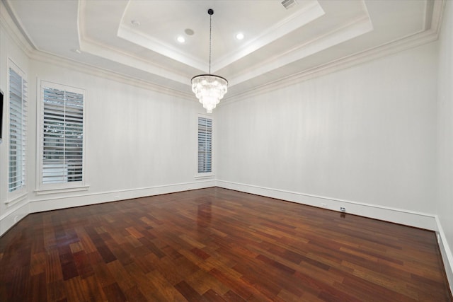 unfurnished room featuring ornamental molding, hardwood / wood-style flooring, an inviting chandelier, and a raised ceiling