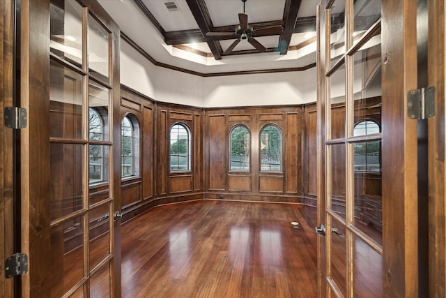 unfurnished room featuring beam ceiling, a high ceiling, coffered ceiling, dark wood-type flooring, and crown molding