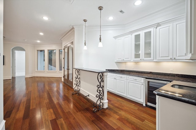 kitchen with white cabinetry, pendant lighting, beverage cooler, and crown molding