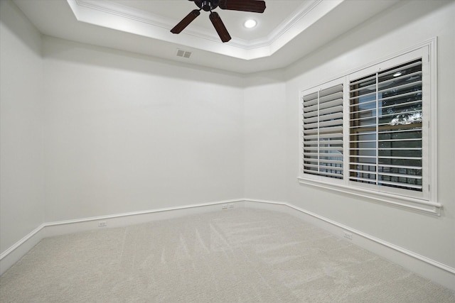 unfurnished room featuring carpet floors, crown molding, ceiling fan, and a raised ceiling