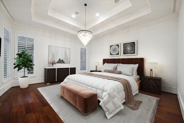 bedroom with ornamental molding, an inviting chandelier, dark hardwood / wood-style flooring, and a raised ceiling