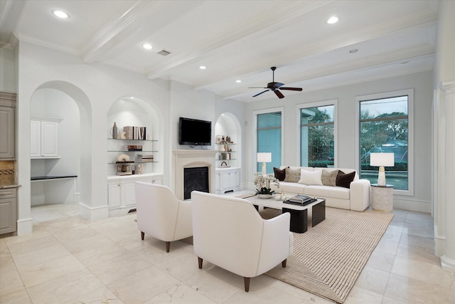 living room featuring ceiling fan, crown molding, built in shelves, and beam ceiling