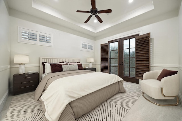 bedroom with a tray ceiling, french doors, access to exterior, and ceiling fan