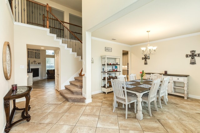 tiled dining area featuring a notable chandelier, a high ceiling, and ornamental molding