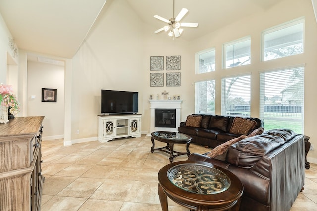 tiled living room featuring ceiling fan and high vaulted ceiling