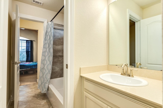 bathroom featuring tile patterned flooring, shower / bathtub combination with curtain, and vanity