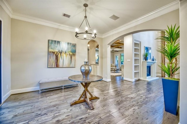 interior space featuring visible vents, arched walkways, ornamental molding, wood finished floors, and a chandelier