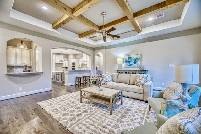 living room with baseboards, arched walkways, visible vents, coffered ceiling, and dark wood finished floors