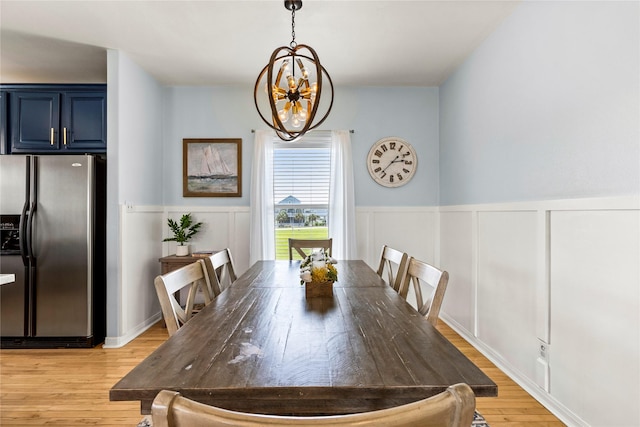 dining area featuring light hardwood / wood-style floors and a notable chandelier