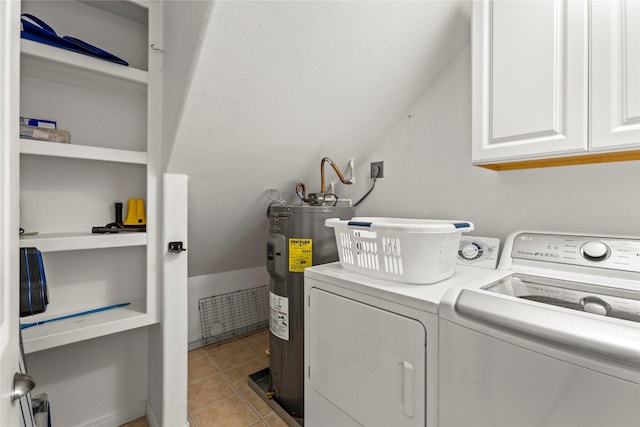 washroom featuring light tile patterned floors, electric water heater, washer and clothes dryer, and cabinets