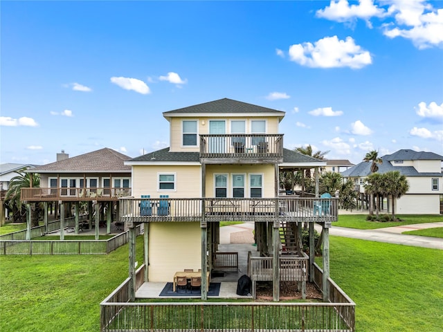 back of house featuring a lawn, a patio, a wooden deck, and a balcony