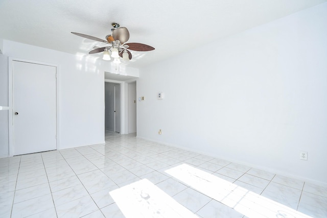 empty room with ceiling fan and light tile patterned floors