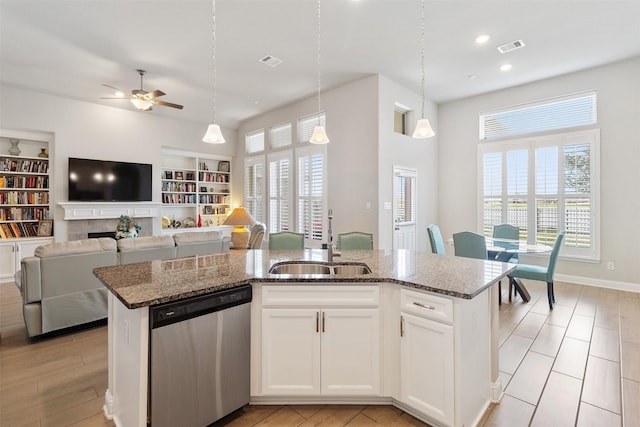 kitchen featuring white cabinetry, a center island with sink, hanging light fixtures, sink, and dishwasher