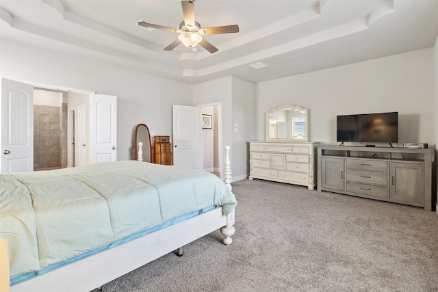 bedroom featuring carpet floors, connected bathroom, ceiling fan, and a raised ceiling