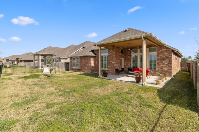 rear view of property with a lawn, ceiling fan, and a patio area