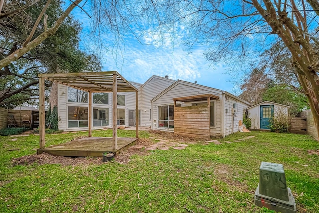 back of property featuring a storage unit, a lawn, and a wooden deck