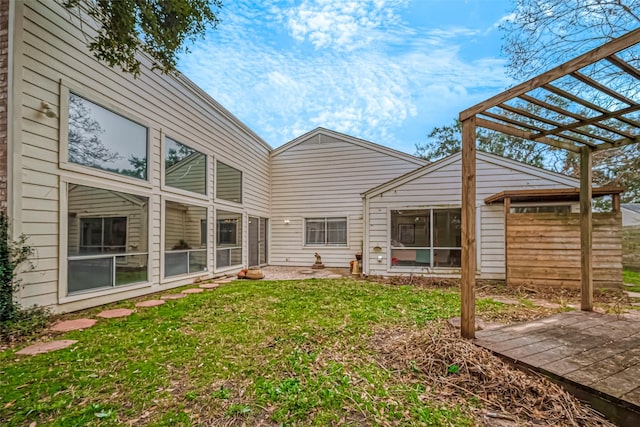 rear view of house featuring a lawn and a pergola