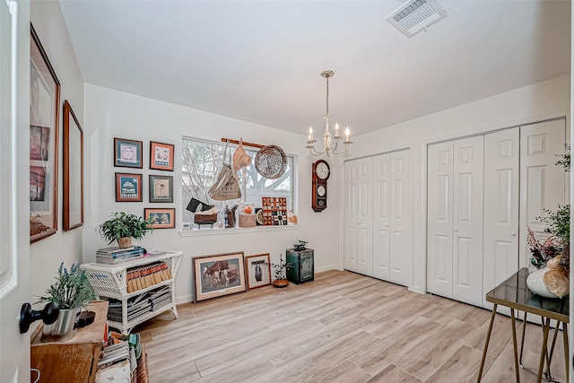 sitting room featuring light wood-type flooring and a chandelier