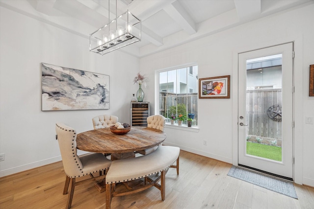 dining room with coffered ceiling, baseboards, and light wood finished floors