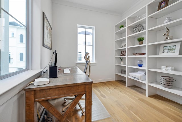 home office with ornamental molding, light wood finished floors, and baseboards