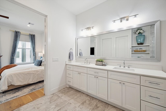 ensuite bathroom with double vanity, ensuite bath, visible vents, and a sink