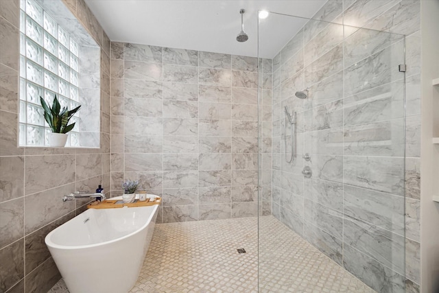 bathroom featuring tiled shower, a freestanding bath, and tile walls