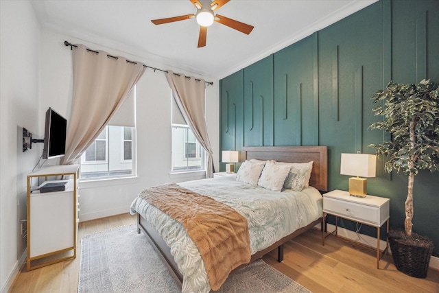 bedroom featuring light wood finished floors, baseboards, and a ceiling fan