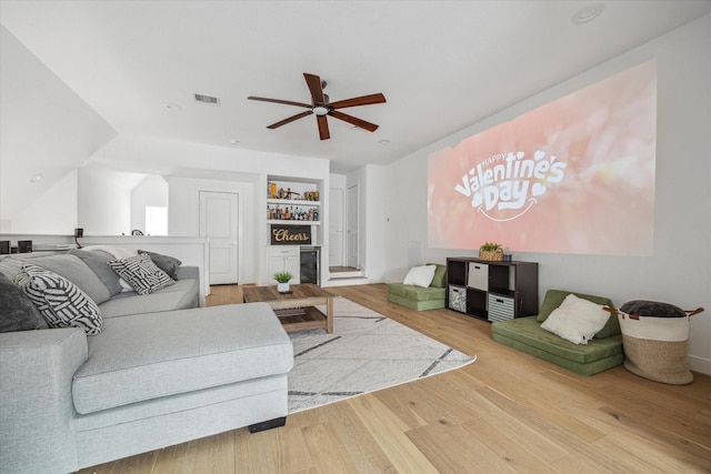 living area with visible vents, wood finished floors, and a ceiling fan