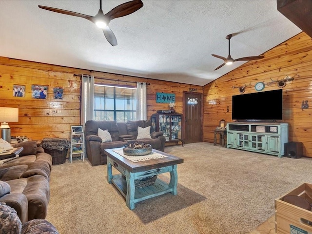 living room with light carpet, ceiling fan, vaulted ceiling, a textured ceiling, and wood walls