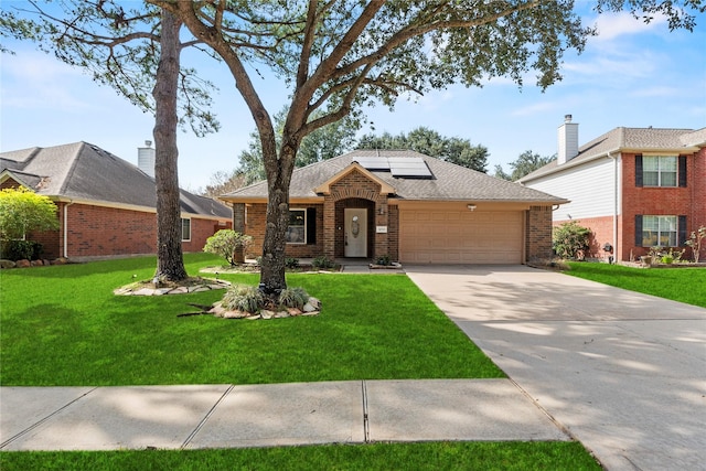 view of front of home with a front lawn, solar panels, and a garage