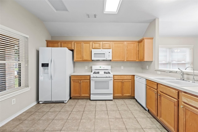 kitchen with white appliances, vaulted ceiling, sink, and light tile patterned floors