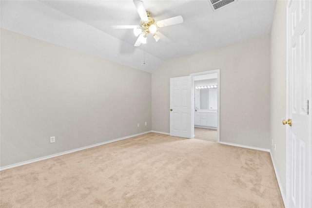 unfurnished bedroom with ceiling fan, vaulted ceiling, ensuite bath, and light colored carpet