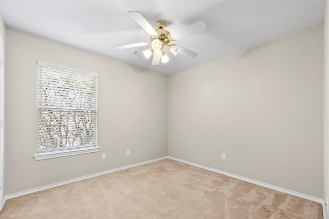 spare room featuring light colored carpet and ceiling fan