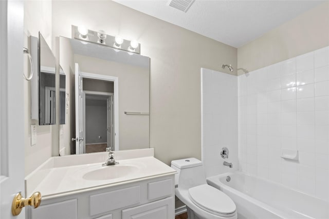 full bathroom with tiled shower / bath combo, vanity, toilet, and a textured ceiling