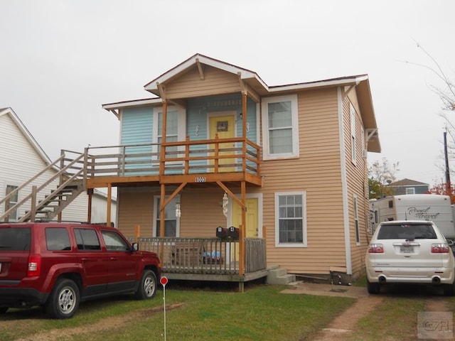 view of front of property with a wooden deck and a front yard